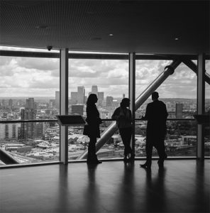 three individuals looking out window